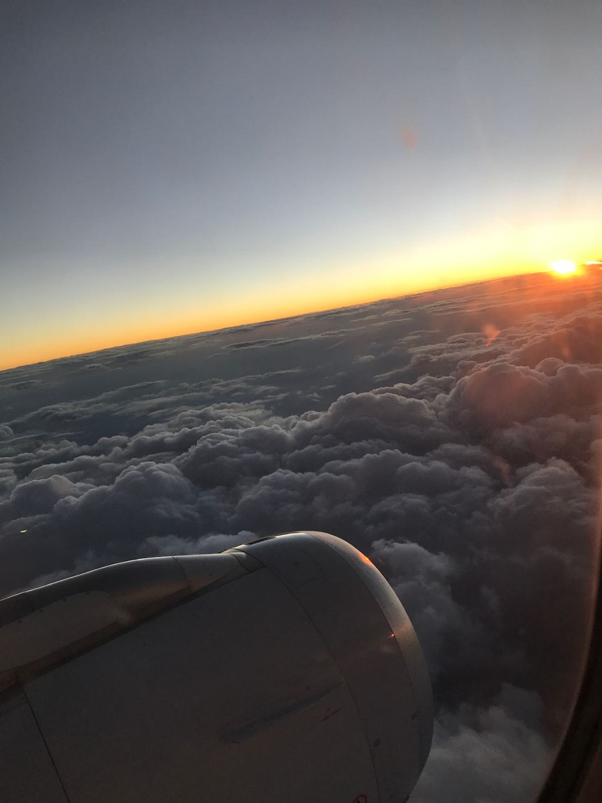 Sunrise over clouds from an airplane window